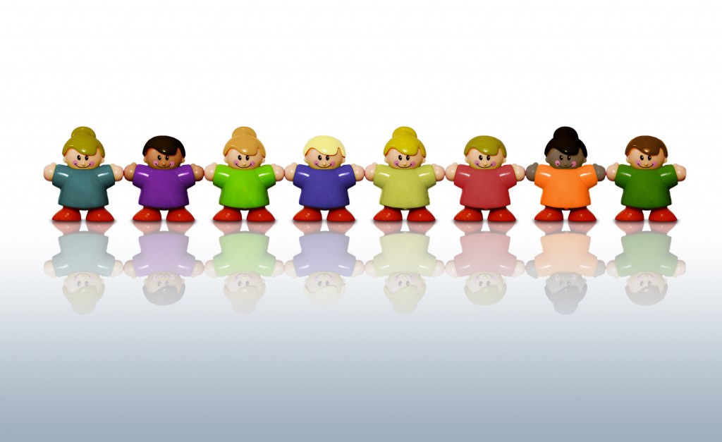 Shows a picture with 8 plastic little figures like children holding hands. All wearing different outfits. 