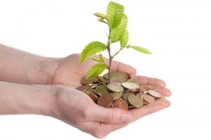 money coins in human hands with a tree sapling growing out of it denoting free church accounting software