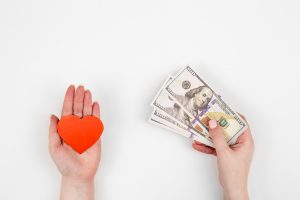 One Hand with paper heart and one hand with money on a white background