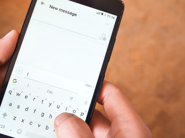 text messaging with mobile device. it shows the cell phone and a person typing into it.