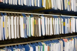 shelf full of file folders filled with documents that are replaced with software programs for church