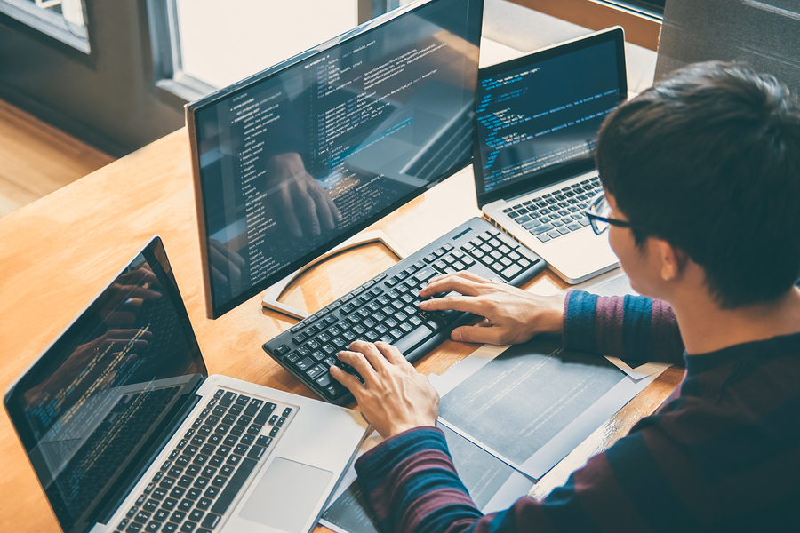 Church software security expert checking the database on multiple monitors.