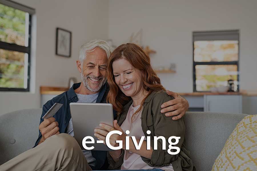 A couple giving to their church through a mobile device and the church's e-Giving platform.