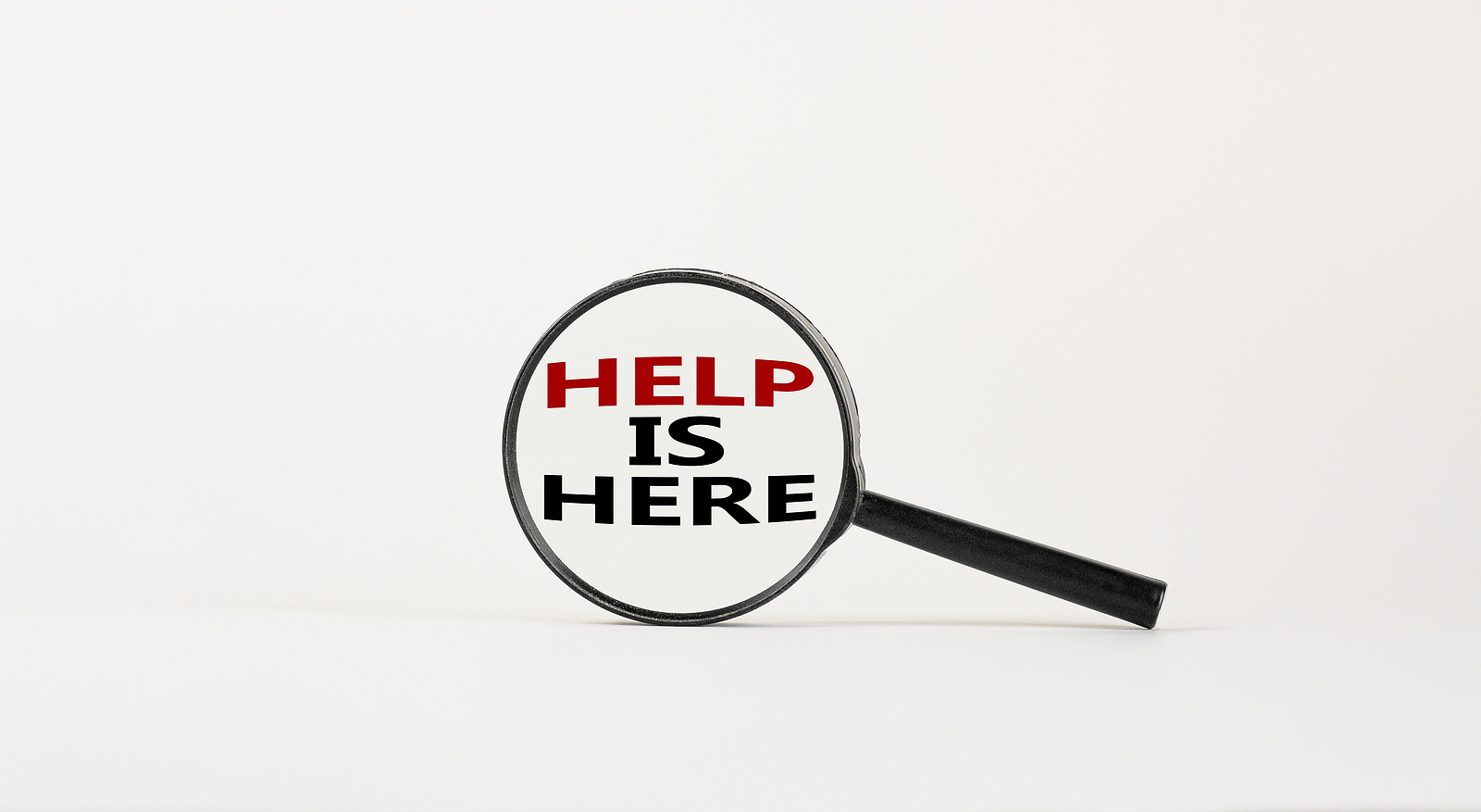 Here to help symbol. Magnifying glass with text 'help is here' on beautiful white background. Business and help is here concept, copy space.
